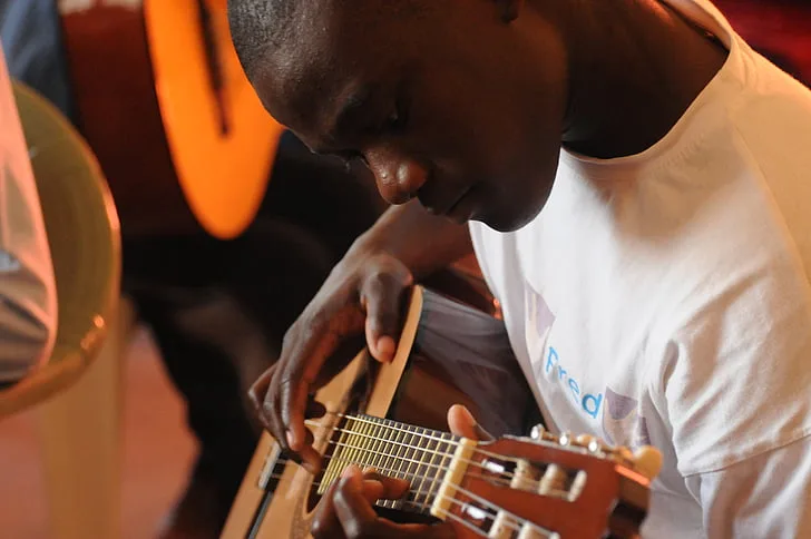 Boy being taught guitar